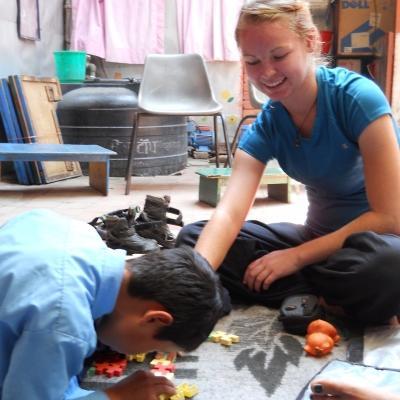 A student on a Physiotherapy internship for high school students in Nepal, works with a young child. A child and Projects Abroad student work on an activity on the Physiotherapy internship for teenagers in Nepal.